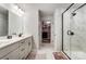 Bright main bathroom features double vanity, marble tile, and glass enclosed shower with walk-in closet at 1112 Drummond Ave, Charlotte, NC 28205