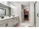 Bright main bathroom features double vanity, marble tile, and glass enclosed shower with walk-in closet at 1112 Drummond Ave, Charlotte, NC 28205