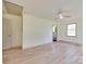 A spacious bedroom with a door leading to a bathroom, a ceiling fan, and light-colored wood laminate flooring at 1209 Mount Ulla Hwy, Mooresville, NC 28115