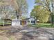 Exterior view of a white home and detached garage showing the expansive yard at 1209 Mount Ulla Hwy, Mooresville, NC 28115