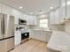 Bright kitchen featuring stainless steel appliances, white cabinets, and mosaic backsplash at 1209 Mount Ulla Hwy, Mooresville, NC 28115