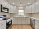 Modern kitchen with white cabinets, stainless steel appliances, and stone countertops at 1209 Mount Ulla Hwy, Mooresville, NC 28115