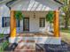 Charming front porch with decorative plants, wooden columns, brick flooring, and a dark front door at 1209 Mount Ulla Hwy, Mooresville, NC 28115