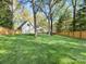 Spacious backyard with a well-manicured lawn and wooden fence, providing privacy and security at 1210 Sewickley Dr, Charlotte, NC 28209