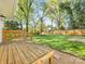 Expansive backyard featuring a well-maintained lawn, wooden deck, and mature trees at 1210 Sewickley Dr, Charlotte, NC 28209