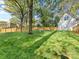 Lush backyard featuring an expansive lawn, mature trees, and a charming swing at 1210 Sewickley Dr, Charlotte, NC 28209