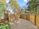 Multi-level backyard with wooden deck, gravel area, and stairs leading to a fenced yard at 1210 Sewickley Dr, Charlotte, NC 28209
