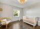 This bright bedroom features hardwood floors, natural light, and a white crib at 1210 Sewickley Dr, Charlotte, NC 28209