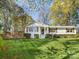 Charming painted brick home featuring a well-manicured lawn, inviting curb appeal, and a spacious front yard at 1210 Sewickley Dr, Charlotte, NC 28209