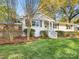 Charming painted brick home featuring a well-manicured lawn, inviting curb appeal, and a wooden deck at 1210 Sewickley Dr, Charlotte, NC 28209