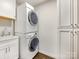 Bright laundry room featuring a stacked washer and dryer, sink, and white cabinets for ample storage at 1210 Sewickley Dr, Charlotte, NC 28209