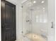 The bright, glass-enclosed shower features marble floors and a built-in bench at 1210 Sewickley Dr, Charlotte, NC 28209