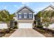 Charming townhome featuring stone accents, gray siding, a two-car garage, and manicured landscaping at 1212 Croft Dr, Fort Mill, SC 29708
