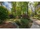Lush backyard featuring mature trees, manicured shrubs, and a winding path for a serene, private setting at 1220 Oakwood Ave, Gastonia, NC 28052