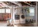 Unfinished basement with washer, dryer, laundry sink, and a door to the exterior at 1220 Oakwood Ave, Gastonia, NC 28052
