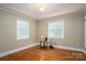 Bright bedroom with two windows bringing natural light and hardwood floors at 1220 Oakwood Ave, Gastonia, NC 28052