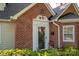 Welcoming brick home with a decorative white-trimmed front door, complemented by lush greenery at 1220 Oakwood Ave, Gastonia, NC 28052