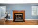 Cozy living room with a decorative fireplace, hardwood floors, and natural light at 1220 Oakwood Ave, Gastonia, NC 28052