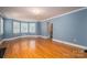 Spacious living room featuring hardwood floors, an arched doorway, and large windows at 1220 Oakwood Ave, Gastonia, NC 28052