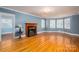 Bright living room with hardwood floors, a fireplace, and ample natural light at 1220 Oakwood Ave, Gastonia, NC 28052
