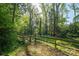 Idyllic shot of a wooden gate leading to a private backyard surrounded by lush greenery and mature trees at 1220 Oakwood Ave, Gastonia, NC 28052
