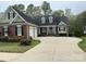 Inviting front exterior featuring a brick facade, well-manicured lawn, and a spacious driveway leading to an attached garage at 127 Victoria Park Dr, Shelby, NC 28150