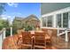 Wooden table and chairs on back deck with rail overlooking backyard and the back of home at 13713 Sunset Bluffs Cir, Huntersville, NC 28078