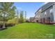 Expansive backyard with lush green lawn, mature trees, and a beautiful patio area, perfect for outdoor activities at 13713 Sunset Bluffs Cir, Huntersville, NC 28078