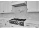 Modern kitchen features stainless steel stove, white cabinets, and tile backsplash at 13713 Sunset Bluffs Cir, Huntersville, NC 28078