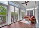 Bright sunroom with floor-to-ceiling windows, ceiling fan, wood floors, and comfortable seating at 13713 Sunset Bluffs Cir, Huntersville, NC 28078