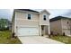 Charming two-story home showcasing a white garage door, neutral siding, and beautifully landscaped front yard at 141 Shepherds Landing Dr, Mooresville, NC 28115