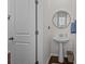 Cozy half-bathroom featuring a pedestal sink, round mirror, and stylish accents with wood grain vinyl flooring at 15122 Lake Ridge Rd, Charlotte, NC 28278