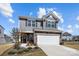 Charming two-story home features gray siding, stone accents, a two-car garage and a welcoming front door at 15122 Lake Ridge Rd, Charlotte, NC 28278