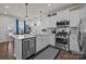 Modern kitchen featuring white cabinets, stainless steel appliances, and a breakfast bar with pendant lighting at 15122 Lake Ridge Rd, Charlotte, NC 28278