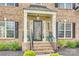 Inviting covered front porch with brick steps, black railing, and attractive landscaping at 1813 Robbins Meadows Dr, Waxhaw, NC 28173