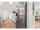 Stainless steel refrigerator stands between the kitchen and living room, featuring white cabinets and countertops at 205 Jim Patterson Rd, Kings Mountain, NC 28086