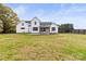 Rear exterior of a farmhouse featuring a patio with an outdoor fireplace and vast backyard at 211 Killian Rd, Stanley, NC 28164