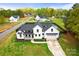 Stunning modern farmhouse with black trim, spacious lawn, and inviting front porch with bench at 211 Killian Rd, Stanley, NC 28164