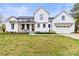 Charming two-story modern farmhouse exterior with black trimmed windows and attached two-car garage at 211 Killian Rd, Stanley, NC 28164