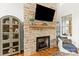 Elegant stone fireplace with a wooden mantel and hearth, along with a built-in display cabinet at 211 Killian Rd, Stanley, NC 28164
