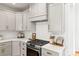 Kitchen with stainless steel gas range, custom range hood, and stylish hardware at 211 Killian Rd, Stanley, NC 28164