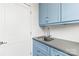 Bright laundry room with light blue cabinets, modern countertops, and stainless-steel sink at 211 Killian Rd, Stanley, NC 28164
