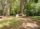 Secluded backyard featuring tall trees, a shed, and a cozy firepit area at 2248 Lawton Bluff Rd, Charlotte, NC 28226