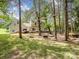 Expansive backyard featuring mature trees, custom play area, and outdoor seating near the home at 2248 Lawton Bluff Rd, Charlotte, NC 28226