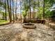 Tranquil backyard featuring a stone fire pit and mature trees, perfect for cozy gatherings at 2248 Lawton Bluff Rd, Charlotte, NC 28226