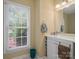 Well-lit half bath with white vanity, ample counter space, and a window providing natural light at 2248 Lawton Bluff Rd, Charlotte, NC 28226