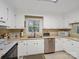Bright kitchen featuring white cabinets, updated appliances, and a skylight for natural lighting at 2248 Lawton Bluff Rd, Charlotte, NC 28226