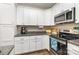 Bright kitchen with white cabinets, stainless steel appliances, and a granite countertop at 2402 Winfield St, Kannapolis, NC 28083