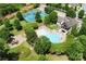 Aerial view showcases community pool, tennis courts, playground and lush landscaping, creating an active lifestyle at 2415 Christenbury Hall Nw Dr, Concord, NC 28027