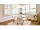 Sun-filled breakfast nook features plantation shutters, wood floors, and a modern glass table at 2415 Christenbury Hall Nw Dr, Concord, NC 28027